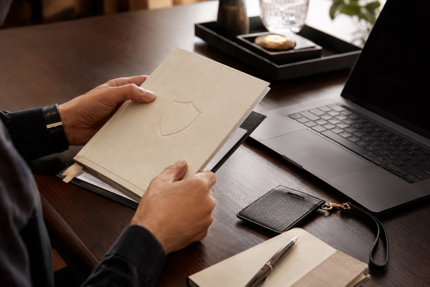 A hand holding a document embossed with a shield, symbolizing controlled access